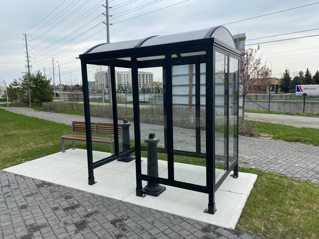 Commercial smoking shelter on concrete pad with a bench