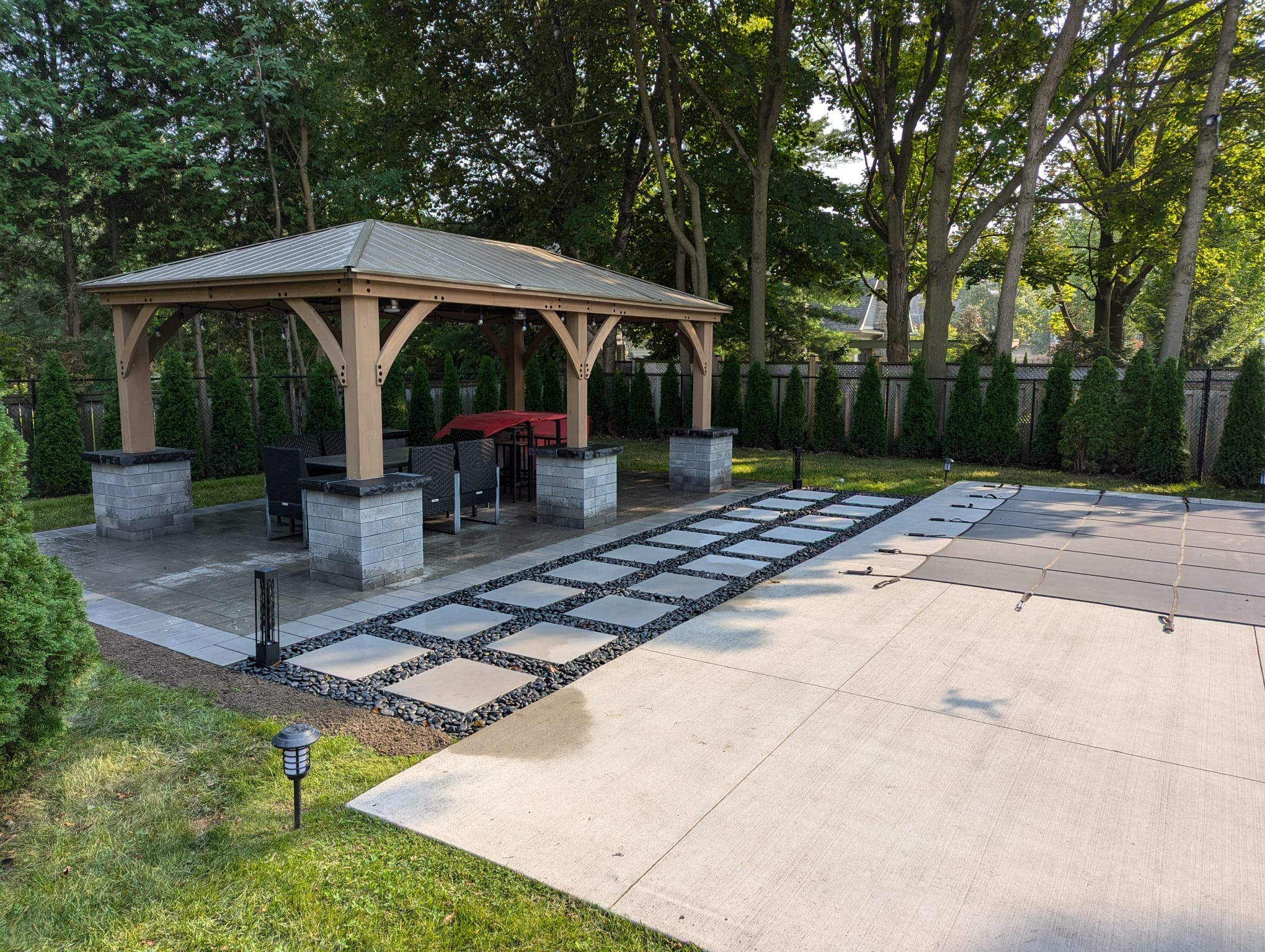 gazebo with large stepping stones surrounded by black polished decor stone