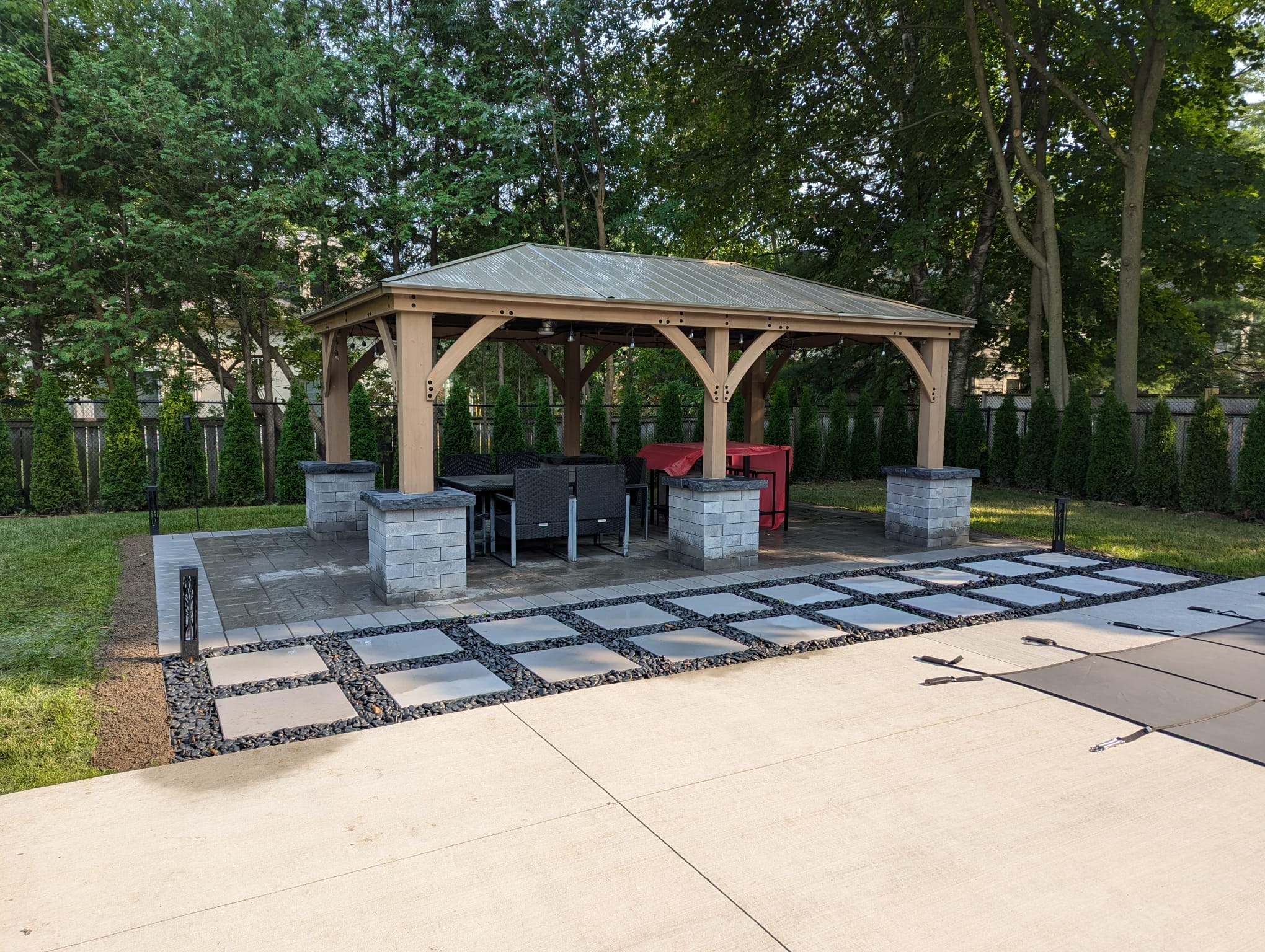 finished gazebo with large stepping stones surrounded by black polished decor stone
