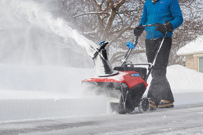 -snowblower- snow blower clearing snow from a driveway